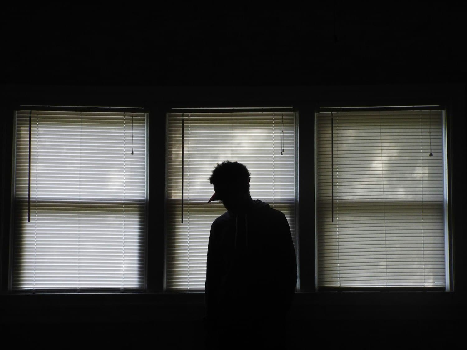 Man standing in front of window blinds